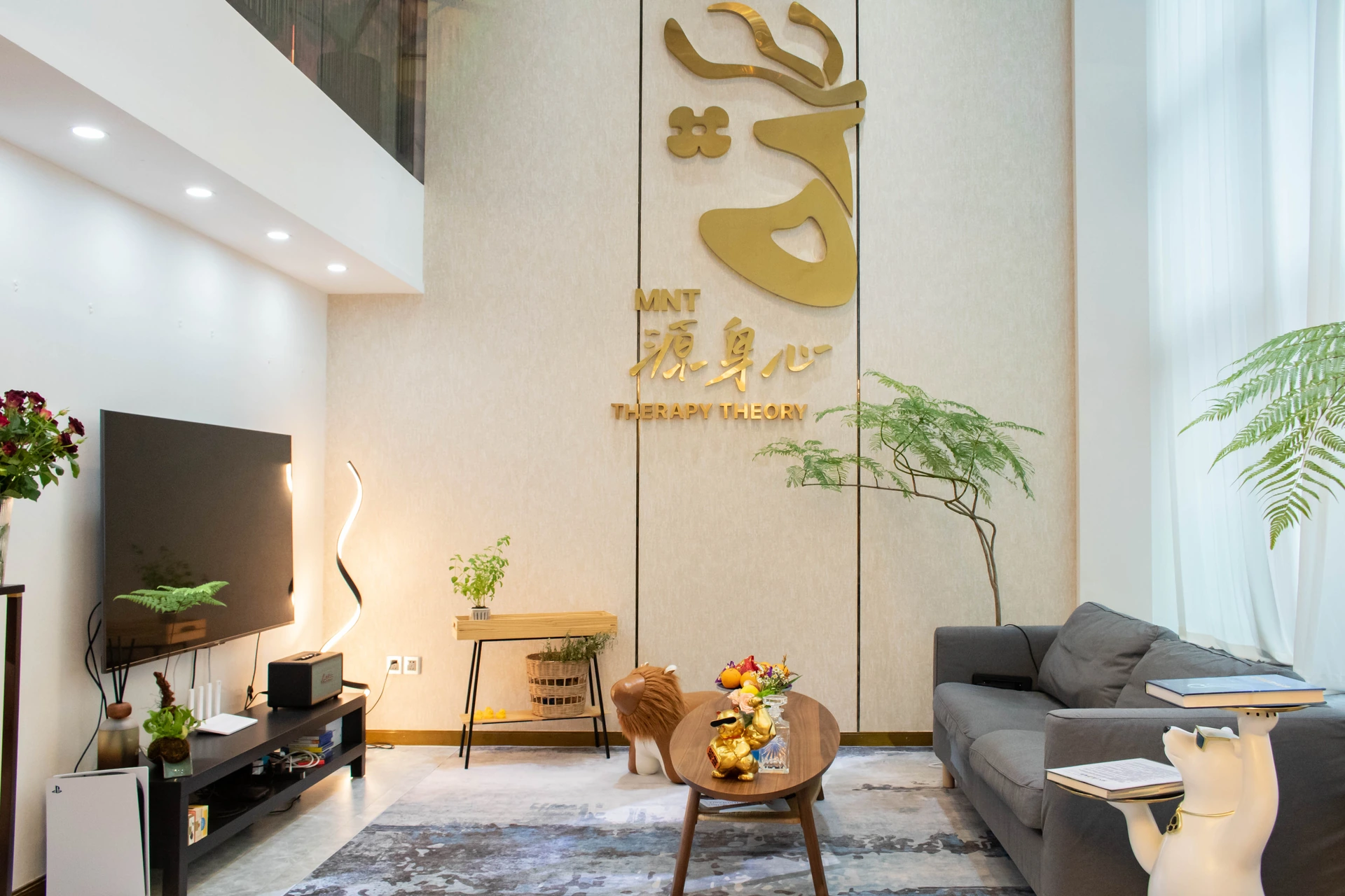 源身心的真实空间，金色品牌墙、落地窗与沙发